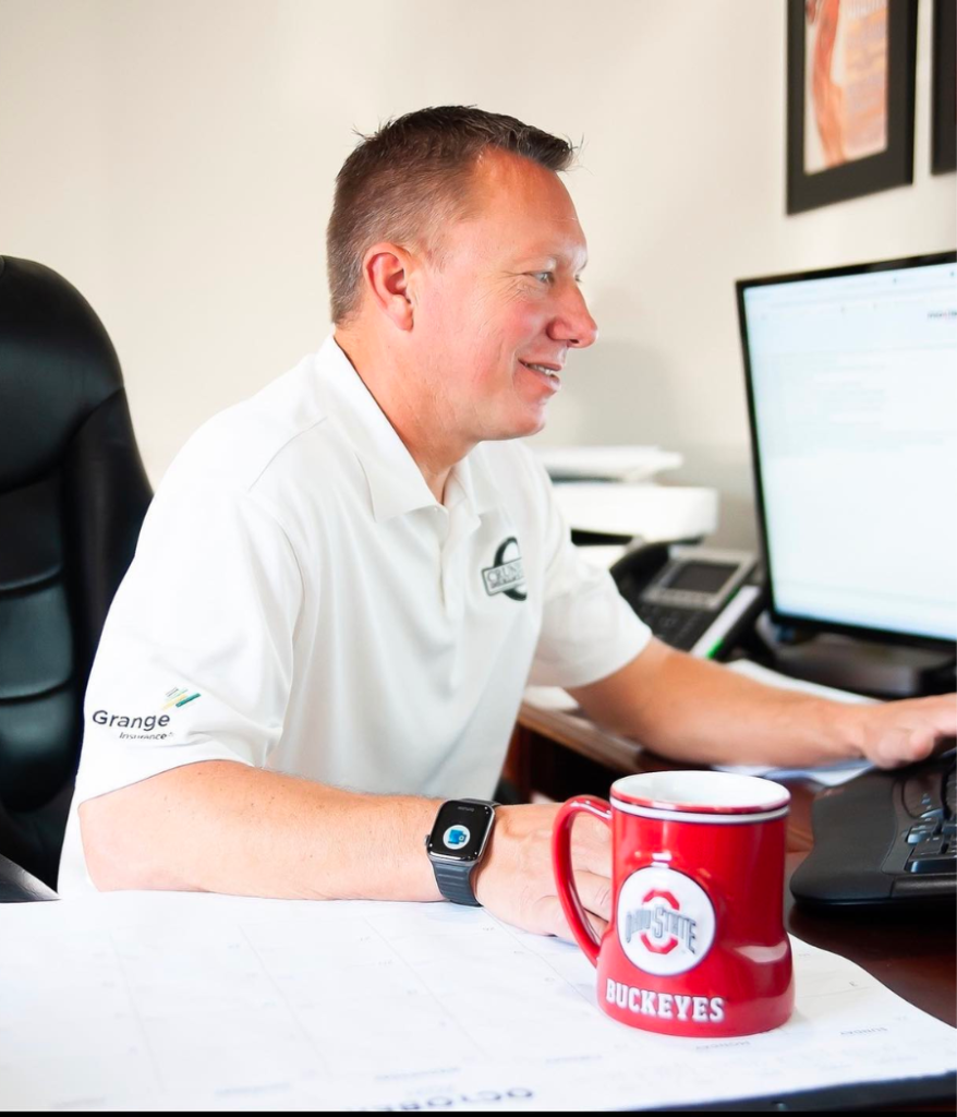 Local Ohio insurance agent Jonathan Crunelle working at his desk with an Ohio State Buckeyes mug.