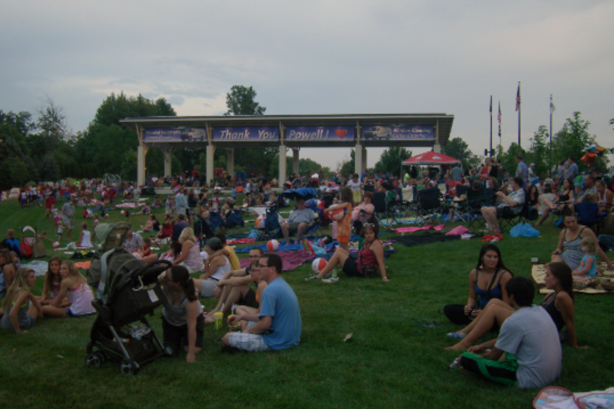 Crowds gathered on a lawn for the Powell Street Festival with a "Thank You Powell" banner in the background.