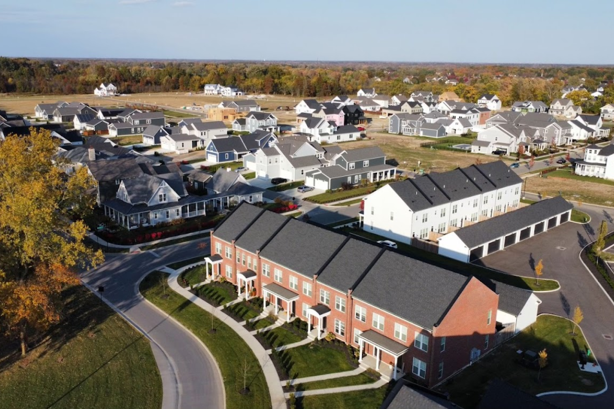 High-angle aerial view of the Evans Farm residential community featuring modern townhomes and suburban houses.