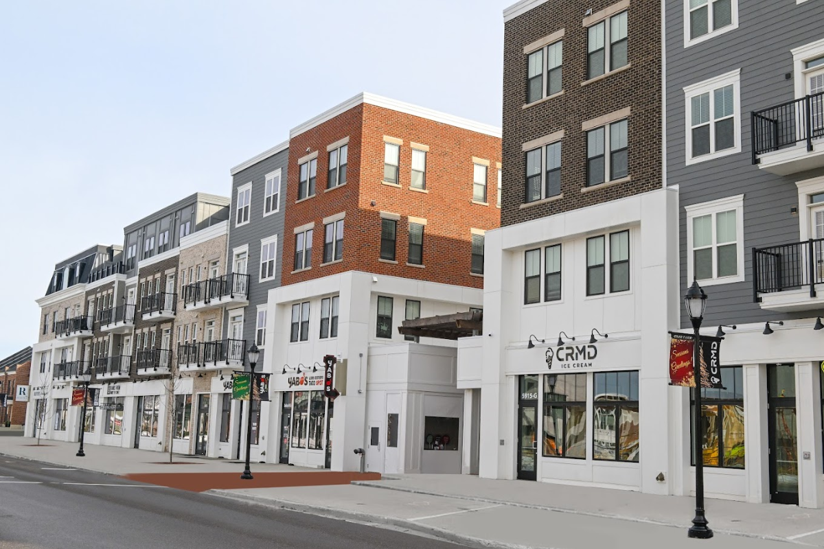 A row of modern mixed-use retail and apartment buildings at Evans Farm with brick and gray siding.