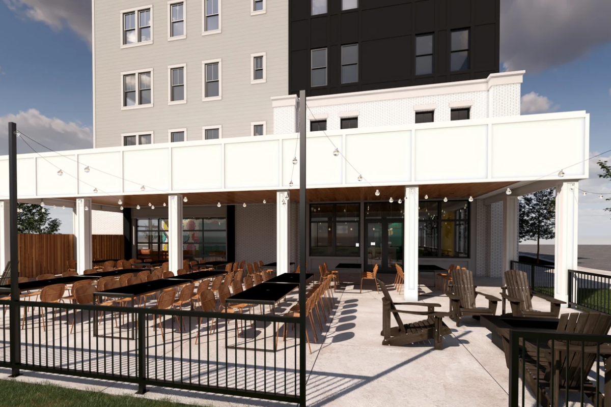 Spacious outdoor patio at Standardized Brewing and Coffee with black tables, Adirondack chairs, and string lights.