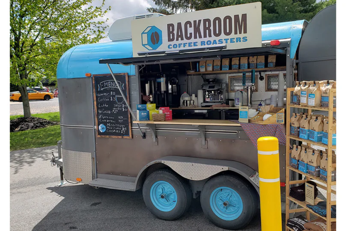 Backroom Coffee Roasters blue and silver mobile coffee trailer with menu board.