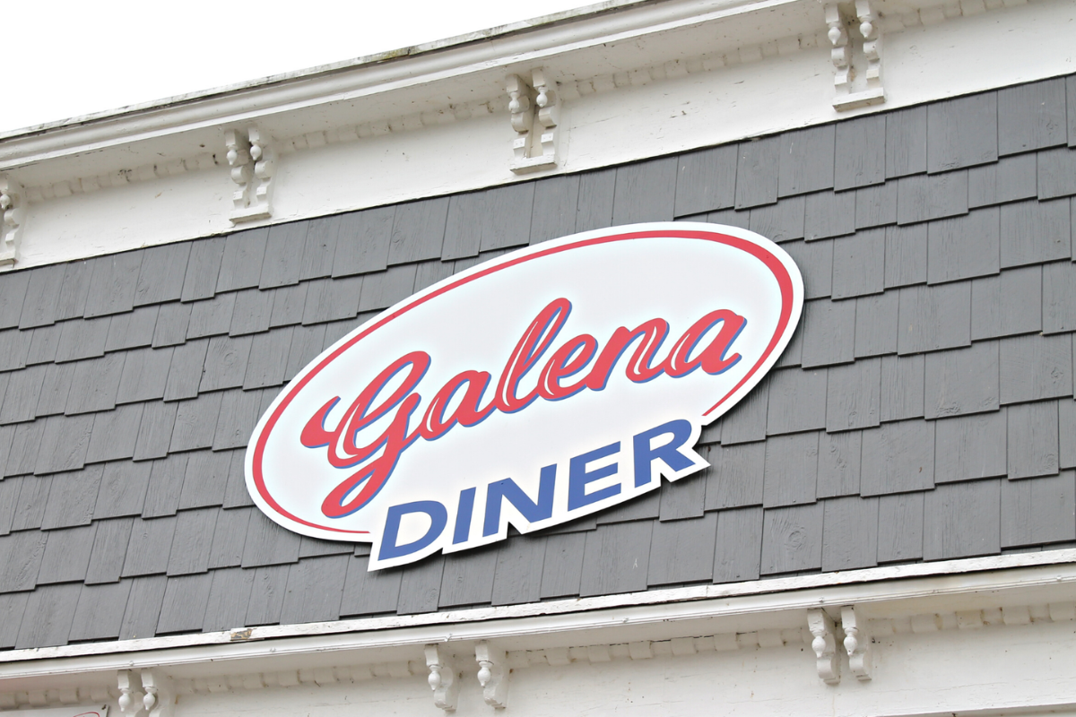 Close-up of the red, white, and blue Galena Diner exterior sign on a gray shingled roof.