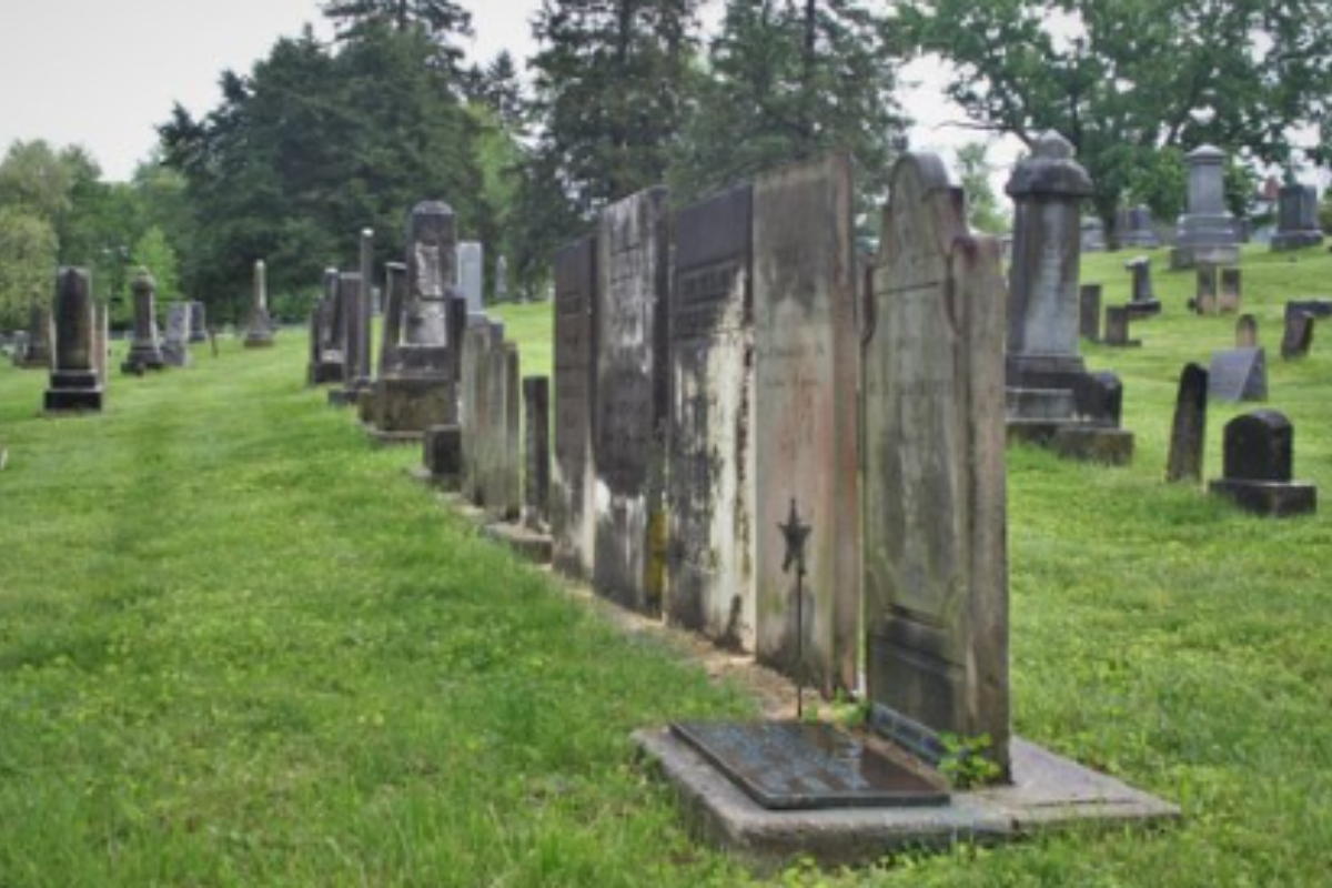 Row of weathered, historic tombstones at the Galena Cemetery in Ohio on a grassy hillside.