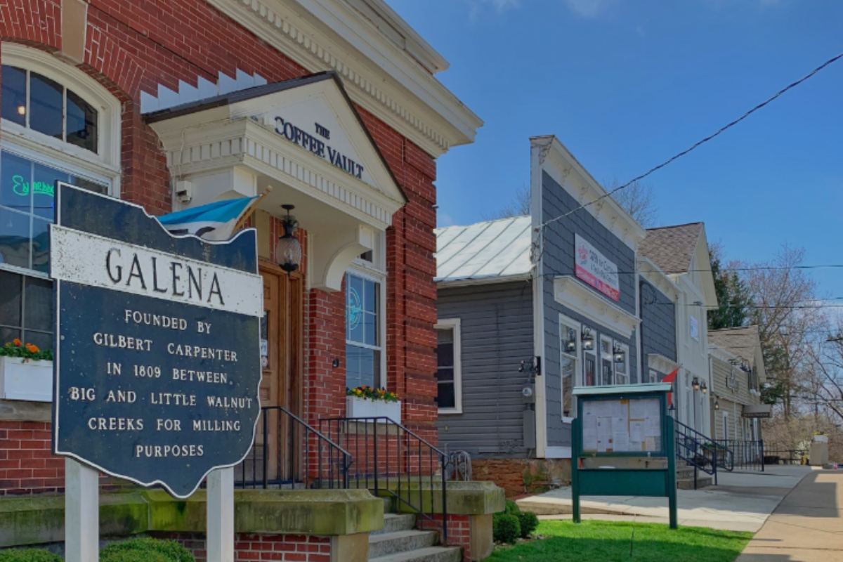 The Coffee Vault and historic markers in downtown Galena Ohio under a blue sky.